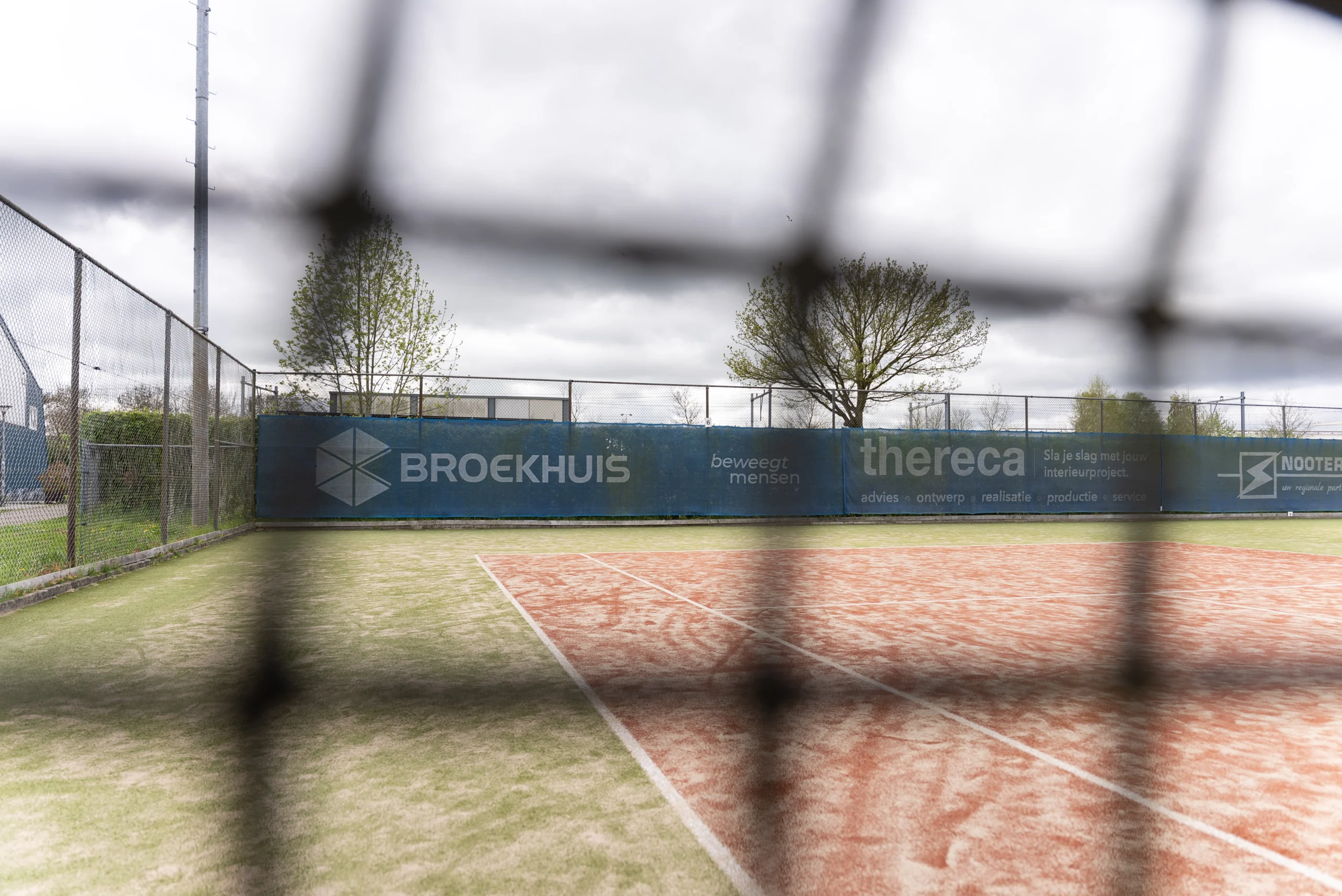 Zicht op de tennisbaan door het net