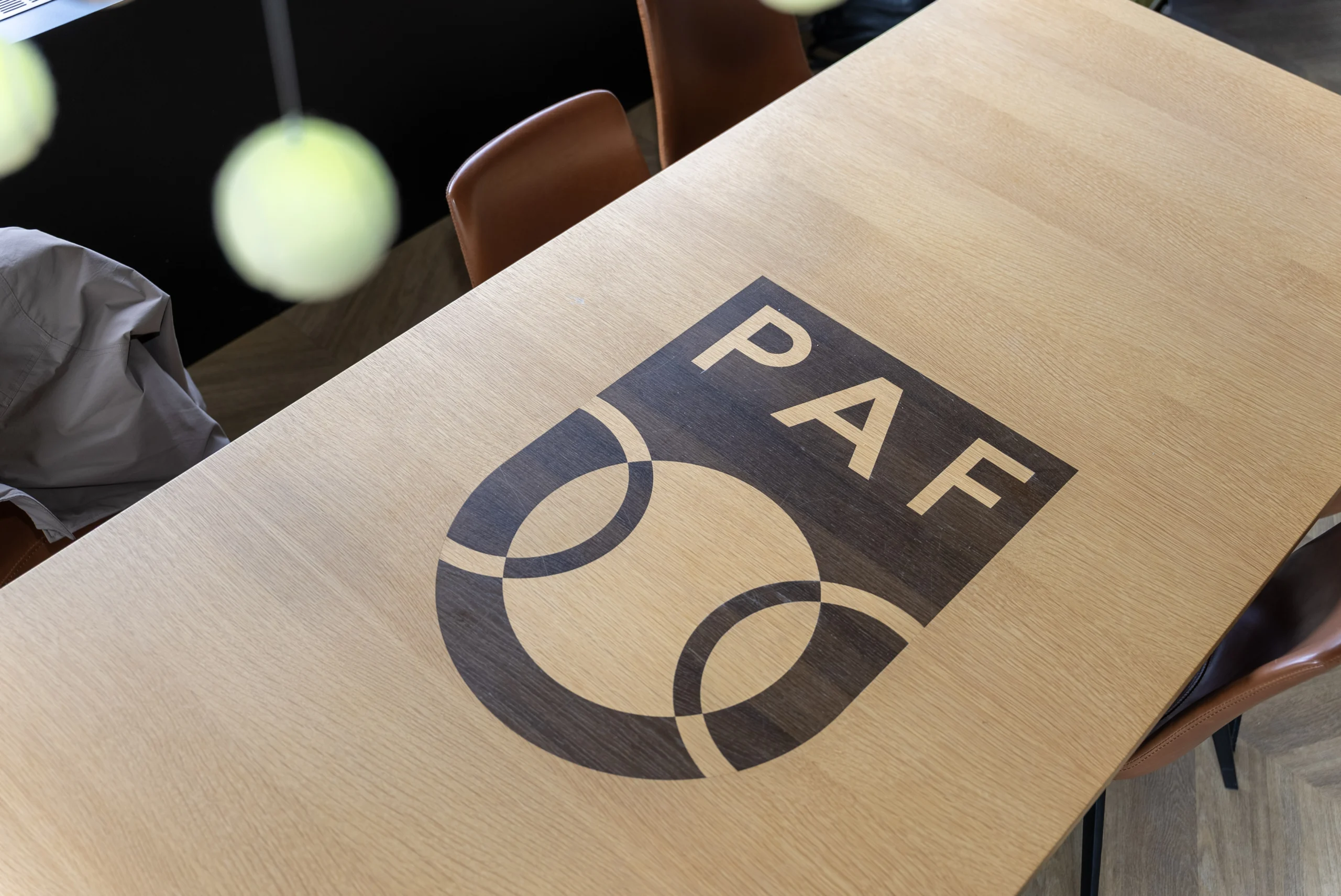 Tafel met PAF-logo en tennisbal in het clubhuis