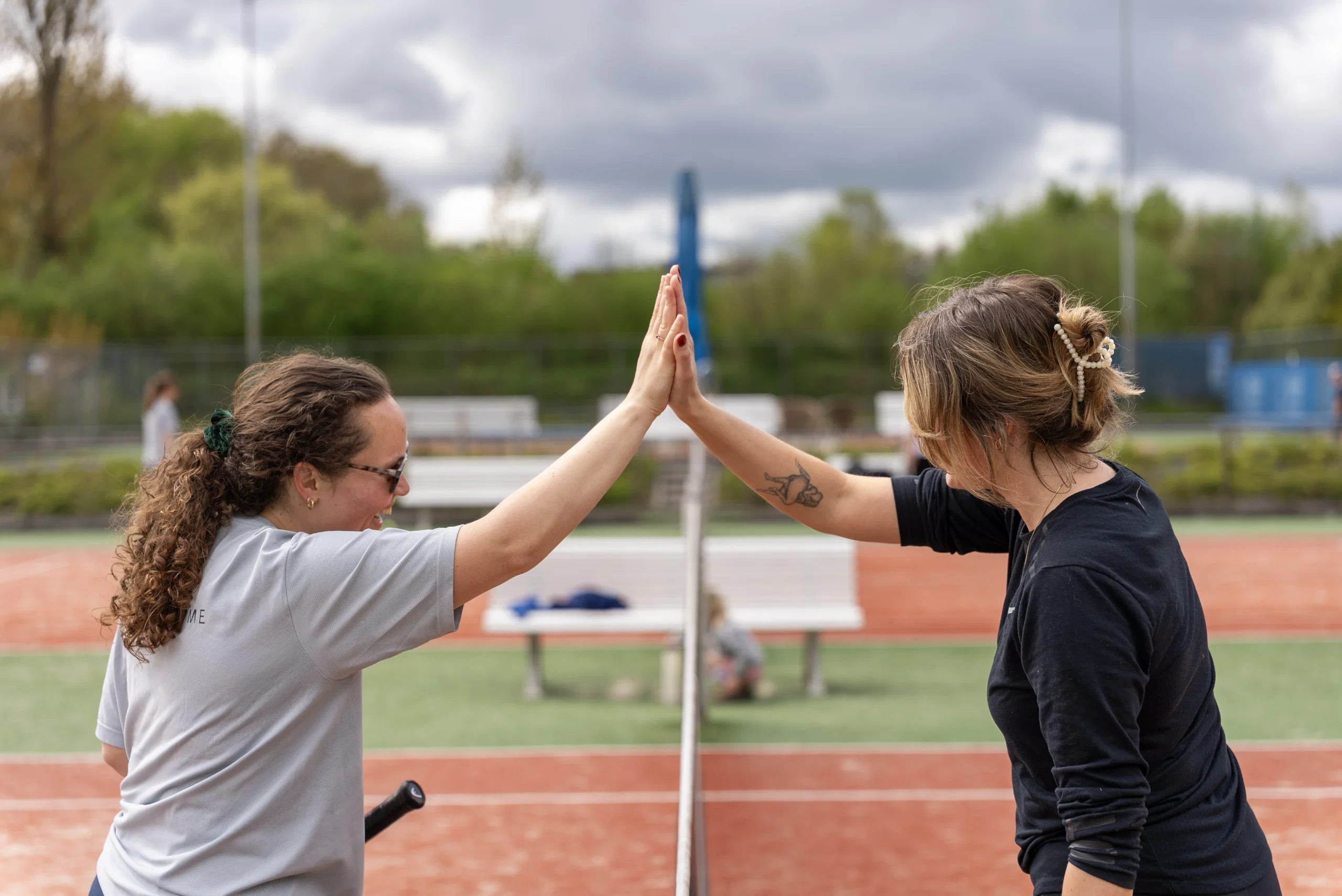 79-DSC07762 Twee spelers geven elkaar een high five op de tennisbaan