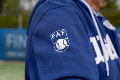 PAF-clublogo op een blauw trainingsvest