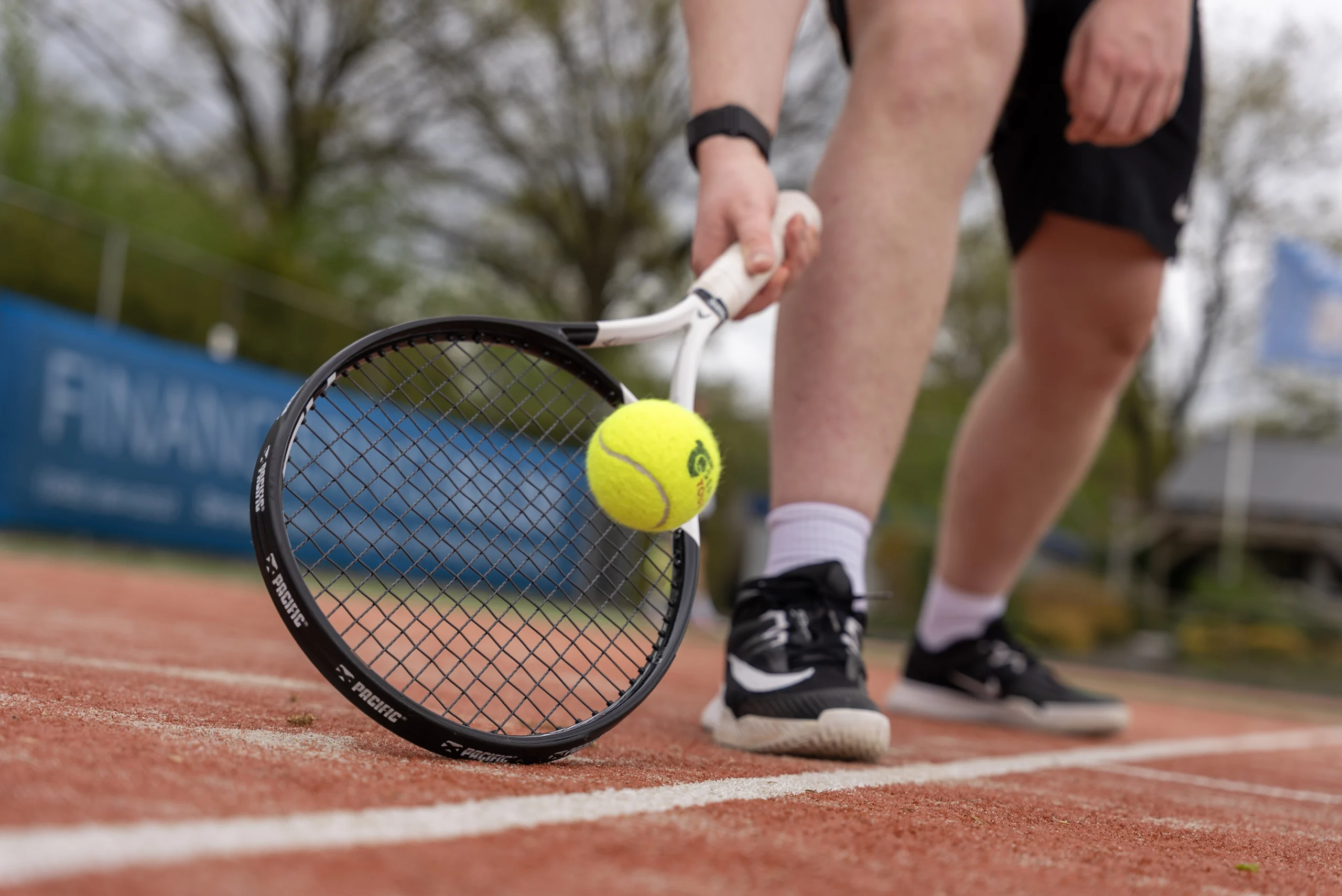 Racket met tennisbal bij het net