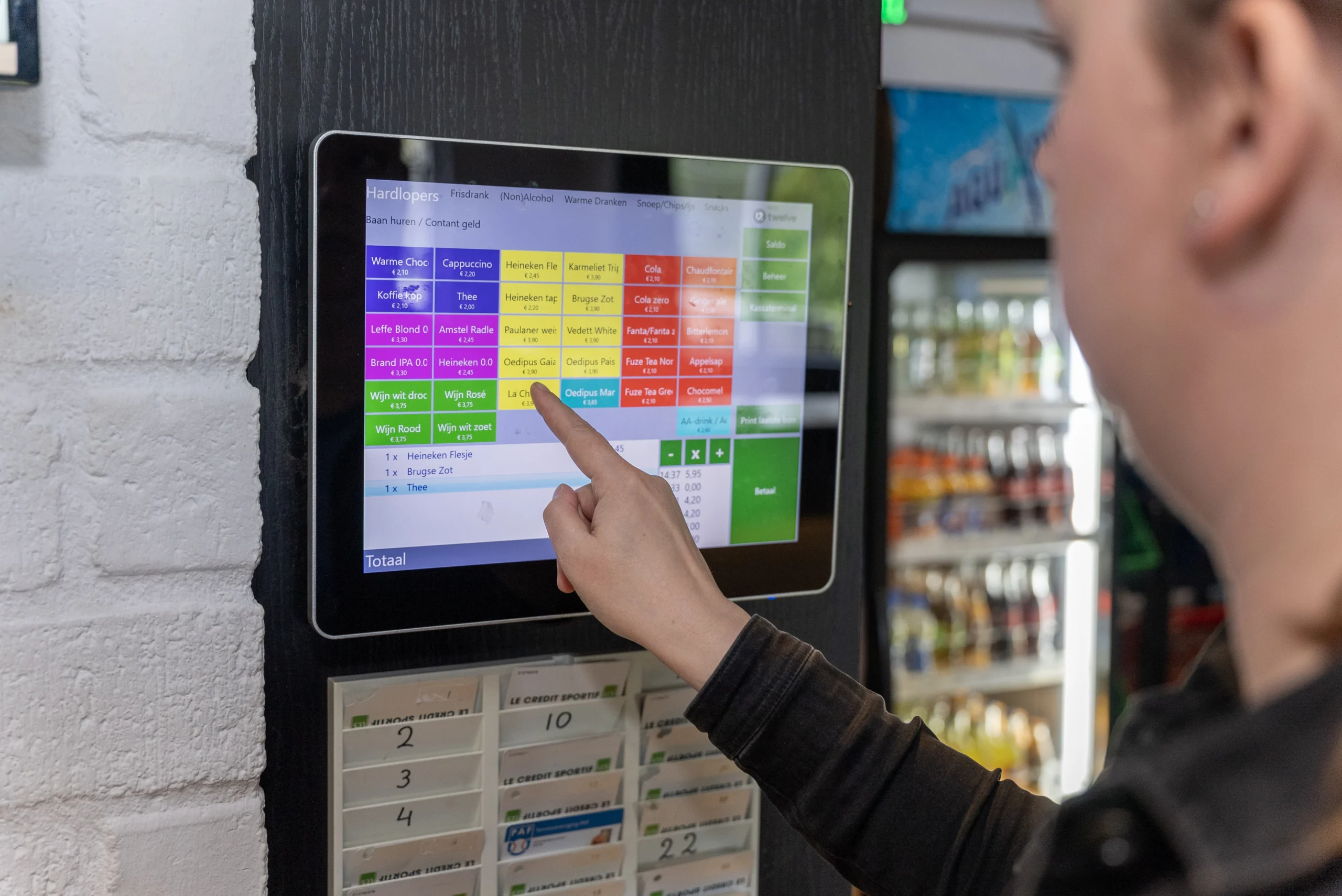 Lid bedient het digitale afhangbord in het clubhuis